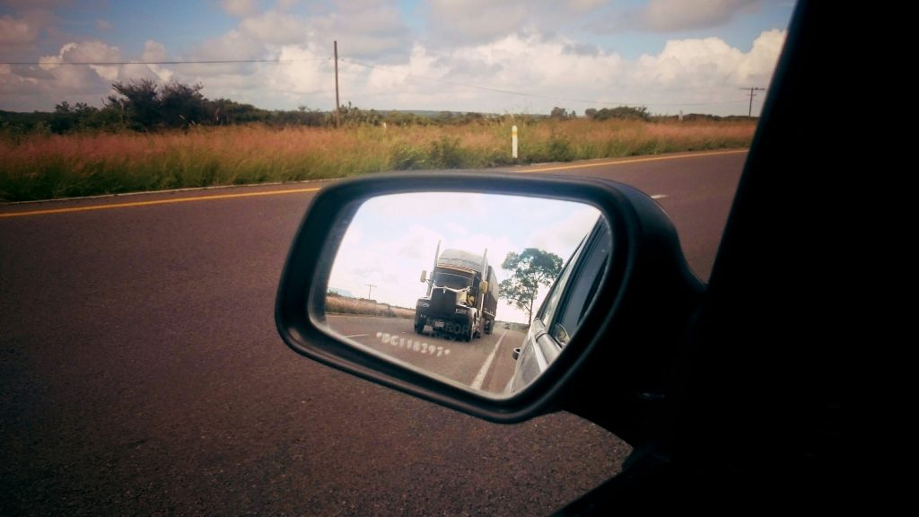Truck reflecting in a car rear view mirror